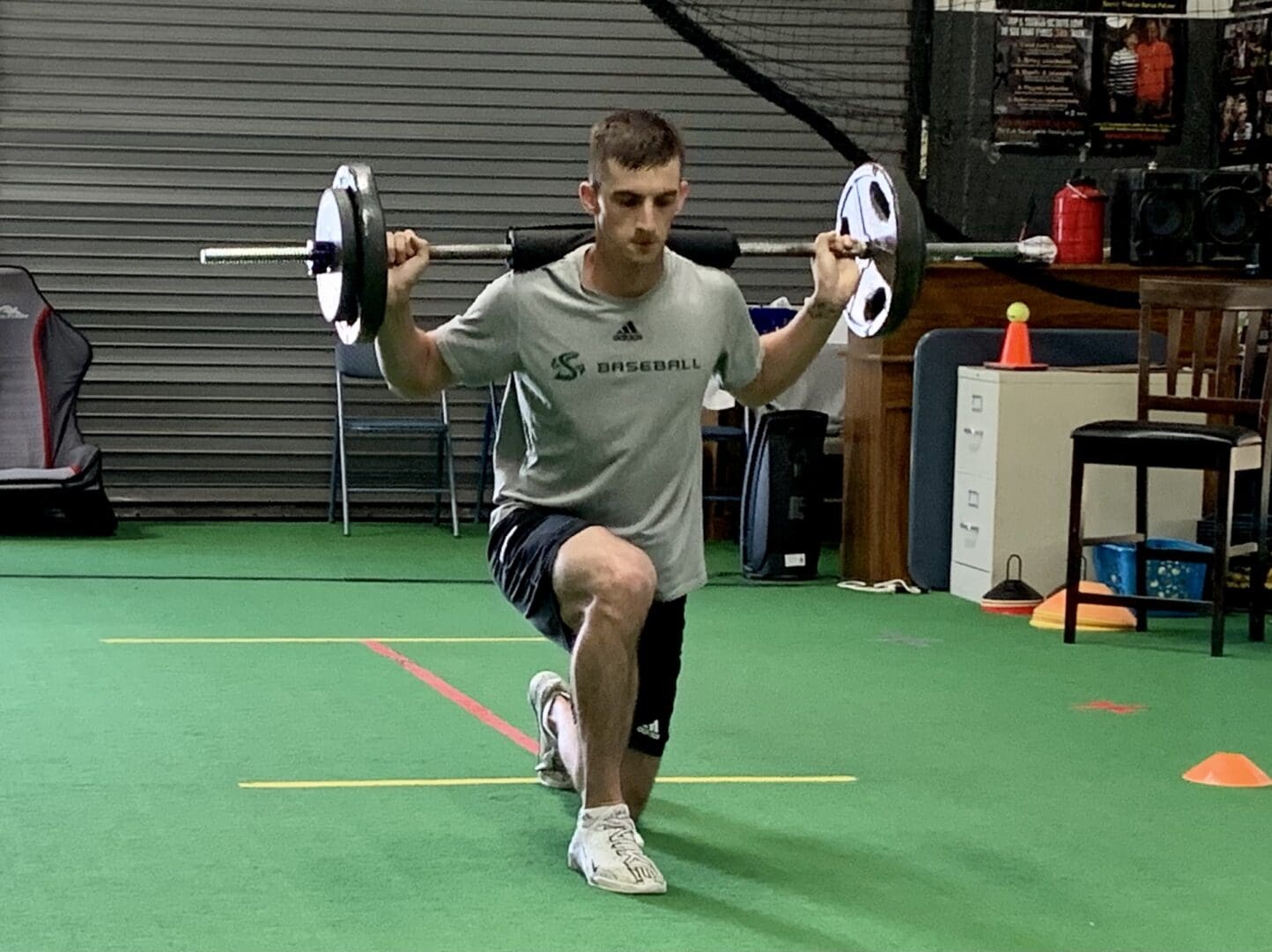 A Male athlete practicing lunges with the barbell